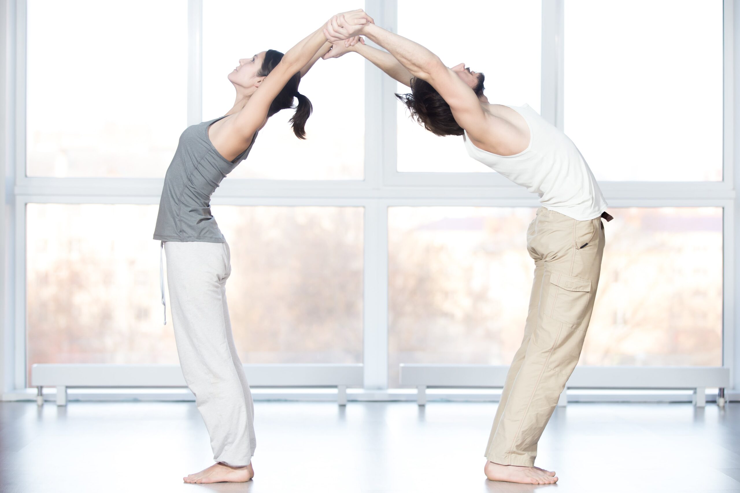 Two person standing forward fold